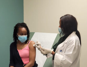 Dr. Okobah about to administer an injection to a young girl