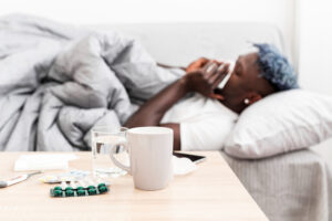 The man is feeling ill with his medications on the table